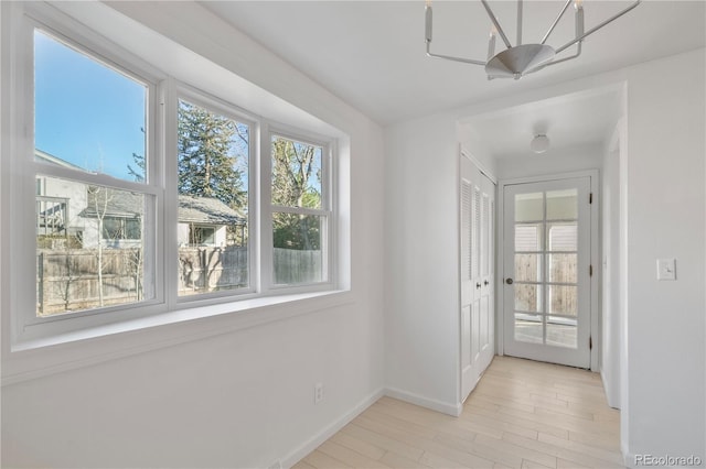 hall featuring baseboards and light wood finished floors