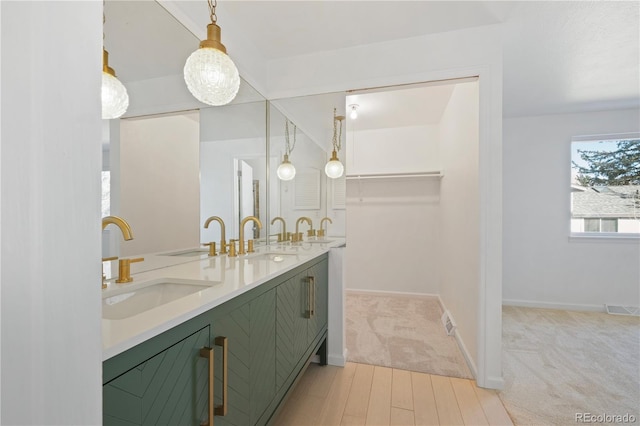 full bathroom featuring baseboards, visible vents, a sink, and double vanity