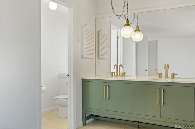 bathroom with double vanity, wood finished floors, toilet, and a sink