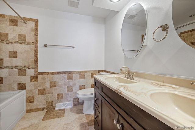 bathroom with tile walls, visible vents, and a sink