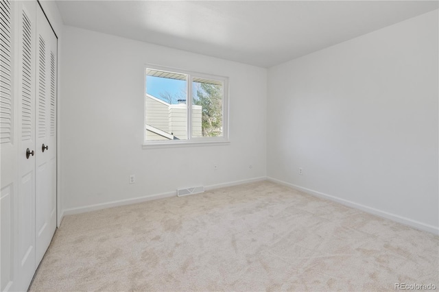 unfurnished bedroom featuring a closet, carpet, baseboards, and visible vents