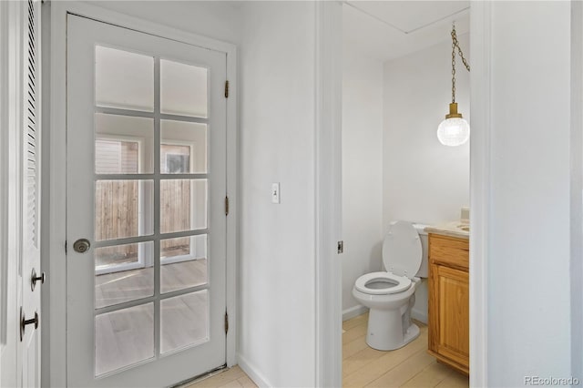 bathroom with baseboards, toilet, and vanity