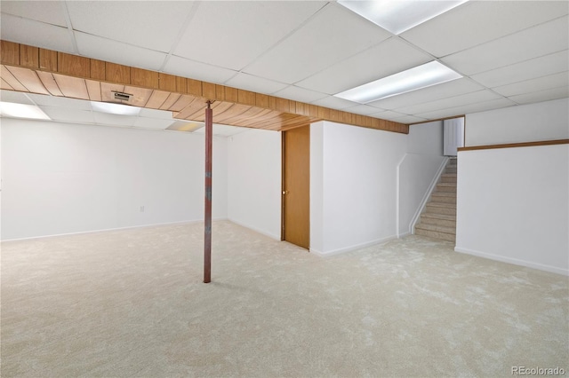 finished basement featuring carpet flooring, visible vents, baseboards, and a paneled ceiling