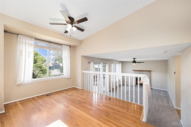 9651 Lameria Dr, Highlands Ranch, CO 80130 - spare room with ceiling fan, wood finished floors, vaulted ceiling, and a brick fireplace