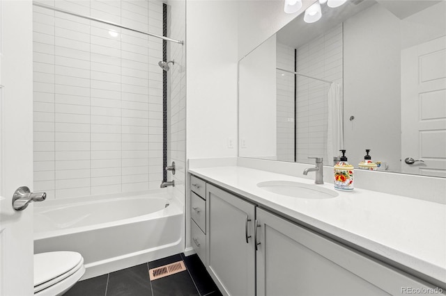 full bathroom featuring tile patterned flooring, vanity, tiled shower / bath combo, and toilet