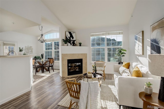 living room with lofted ceiling, hardwood / wood-style floors, and an inviting chandelier