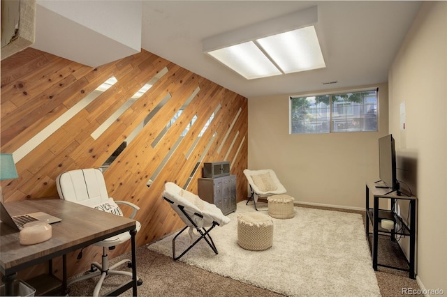 carpeted home office featuring wood walls