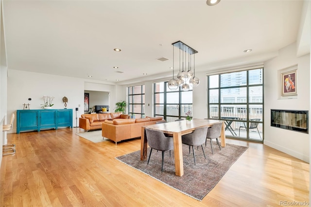 dining room featuring baseboards, visible vents, recessed lighting, light wood-style floors, and a chandelier