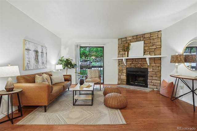 8335 Fairmount Dr Unit 5-106, Denver, CO 80247 - living area featuring wood finished floors, a stone fireplace, and baseboards