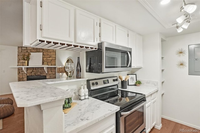 8335 Fairmount Dr Unit 5-106, Denver, CO 80247 - kitchen featuring appliances with stainless steel finishes, electric panel, white cabinetry, light wood-style flooring, and light stone countertops