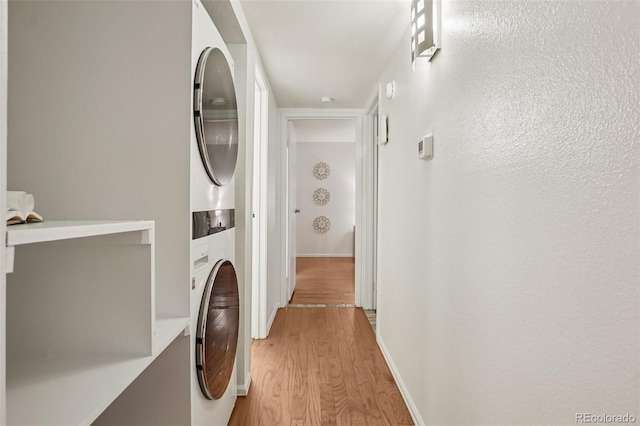 8335 Fairmount Dr Unit 5-106, Denver, CO 80247 - laundry room featuring stacked washer and clothes dryer, light wood-style flooring, and baseboards