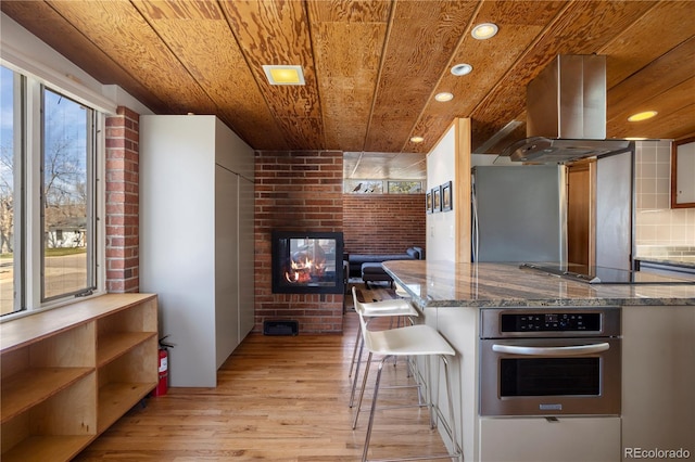 1400 E Bates Ave, Englewood, CO 80113 - kitchen with oven, wooden ceiling, light wood-style floors, recessed lighting, and island range hood