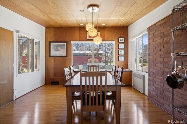 1400 E Bates Ave, Englewood, CO 80113 - dining area with wood finished floors, wood ceiling, brick wall, and a chandelier