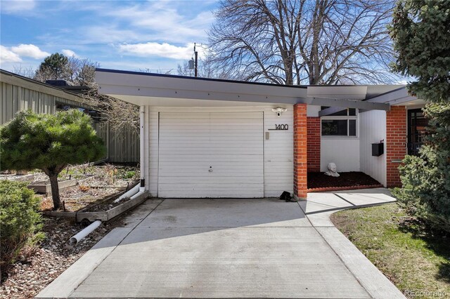 1400 E Bates Ave, Englewood, CO 80113 - garage featuring driveway and a vegetable garden