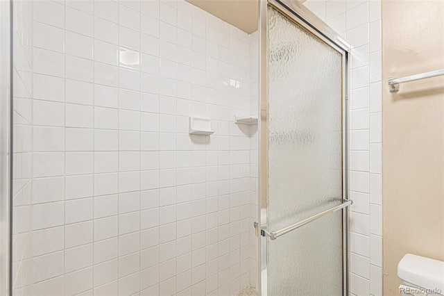 bathroom with an enclosed shower and toilet