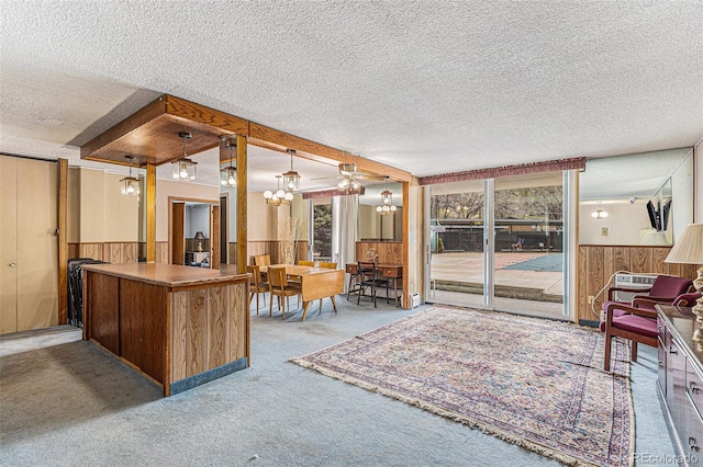 interior space with a notable chandelier, wood walls, and a textured ceiling