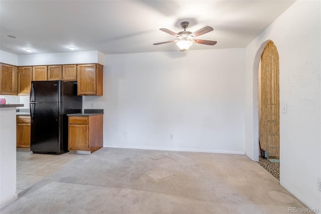 kitchen with black fridge, ceiling fan, and light colored carpet