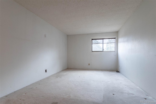 empty room featuring light colored carpet and a textured ceiling