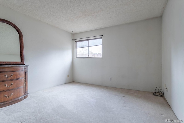 unfurnished room with light carpet and a textured ceiling