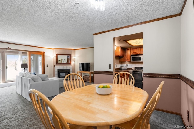 10520 W Jewell Ave Unit 102, Lakewood, CO 80232 - dining room featuring a fireplace, carpet floors, a textured ceiling, and crown molding