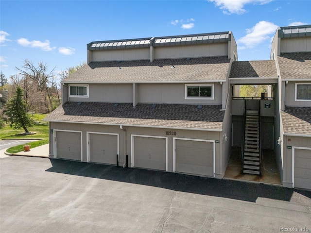 10520 W Jewell Ave Unit 102, Lakewood, CO 80232 - exterior space featuring an attached garage, stairway, and a shingled roof