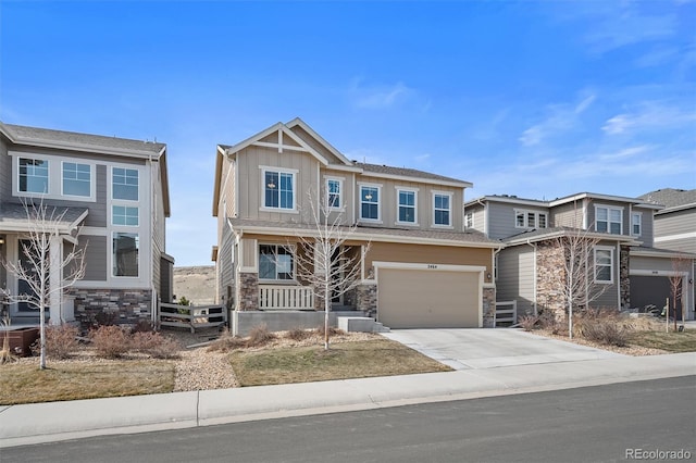 view of front of property with stone siding, concrete driveway, a garage, and fence