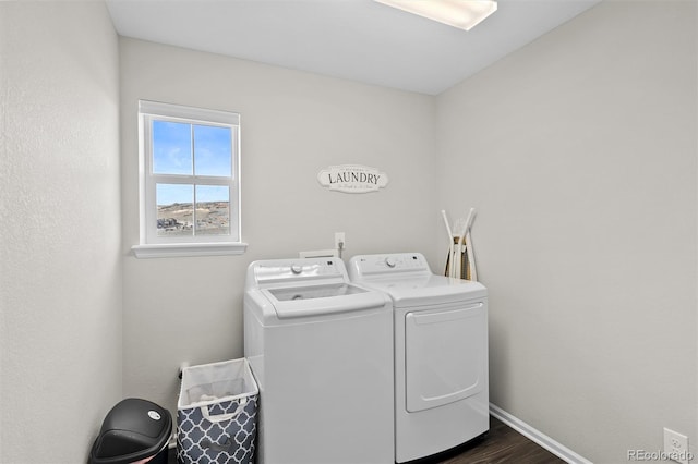 washroom featuring dark wood finished floors, laundry area, baseboards, and independent washer and dryer