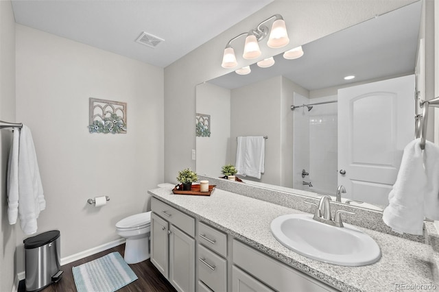 bathroom with vanity, wood finished floors, visible vents, baseboards, and toilet