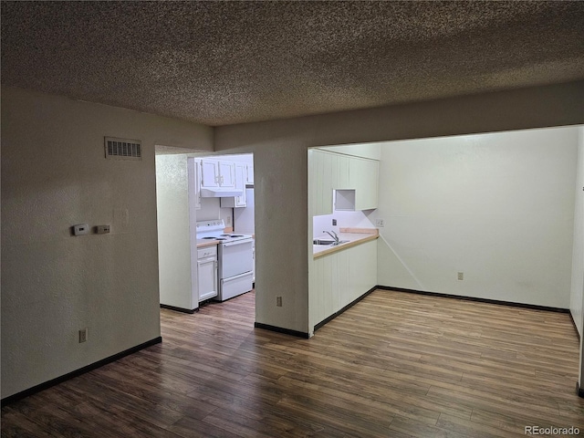 spare room with a sink, dark wood-style flooring, and baseboards