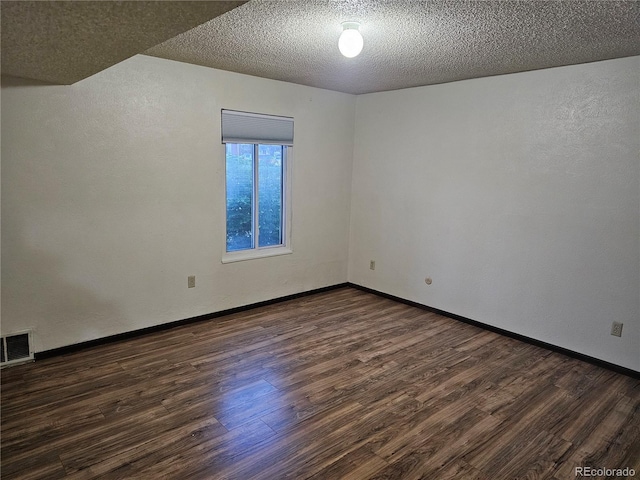 unfurnished room featuring dark wood-style floors, a textured ceiling, and baseboards
