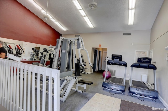 workout area featuring vaulted ceiling and a textured ceiling