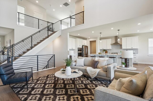 14337 Shasta Daisy Pt, Parker, CO 80134 - living room with wood finished floors, recessed lighting, a towering ceiling, baseboards, and stairway