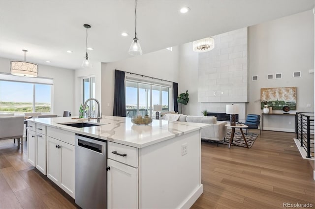 14337 Shasta Daisy Pt, Parker, CO 80134 - kitchen featuring dishwasher, open floor plan, a sink, a towering ceiling, and recessed lighting