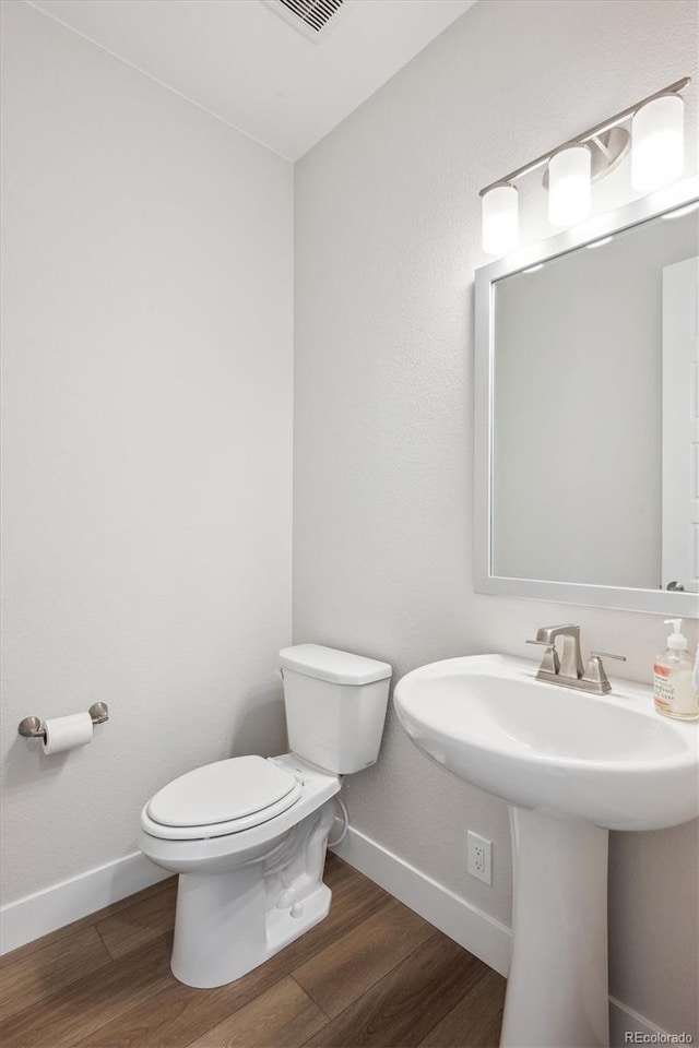 14337 Shasta Daisy Pt, Parker, CO 80134 - half bathroom with toilet, baseboards, wood finished floors, and a sink