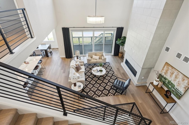 14337 Shasta Daisy Pt, Parker, CO 80134 - living room with a towering ceiling, wood finished floors, baseboards, stairs, and a glass covered fireplace