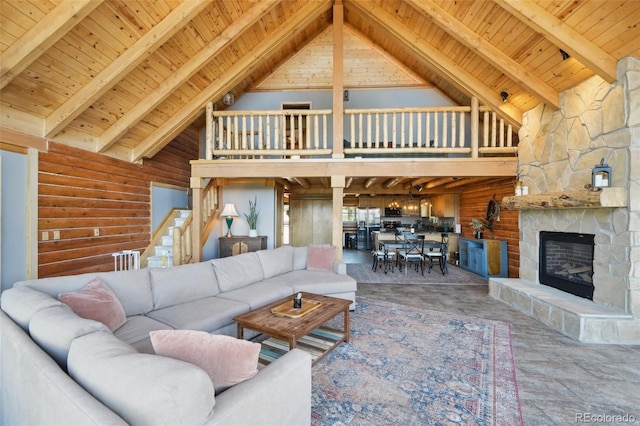 102 Douglas Fir Ln, Woodland Park, CO 80863 - living area featuring rustic walls, a stone fireplace, wooden ceiling, beam ceiling, and high vaulted ceiling