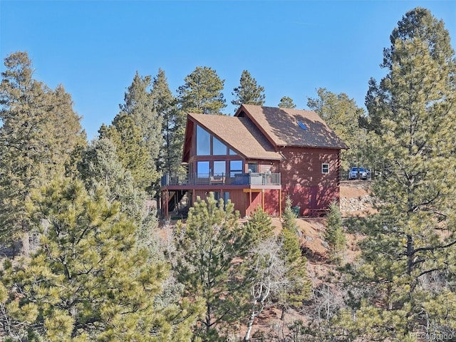 102 Douglas Fir Ln, Woodland Park, CO 80863 - rear view of property featuring a wooden deck and roof with shingles