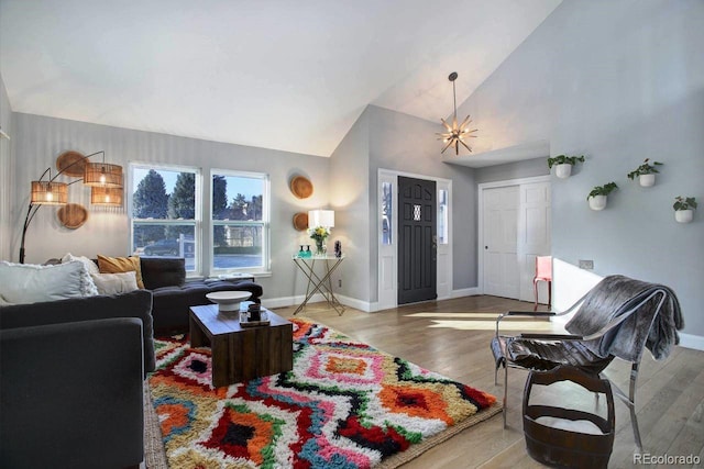 living room featuring lofted ceiling, wood-type flooring, and a notable chandelier