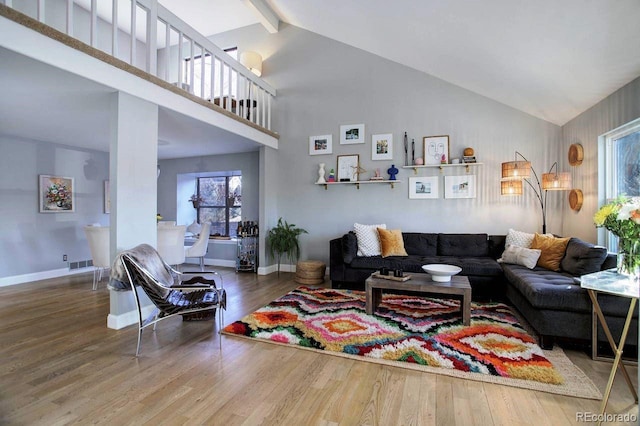 living room featuring high vaulted ceiling and hardwood / wood-style floors