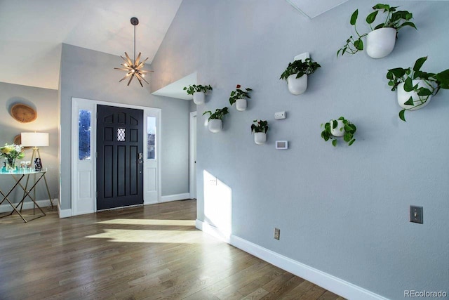 entrance foyer featuring lofted ceiling, a notable chandelier, and hardwood / wood-style flooring