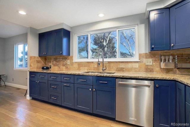 kitchen featuring light hardwood / wood-style floors, decorative backsplash, blue cabinets, stainless steel dishwasher, and sink