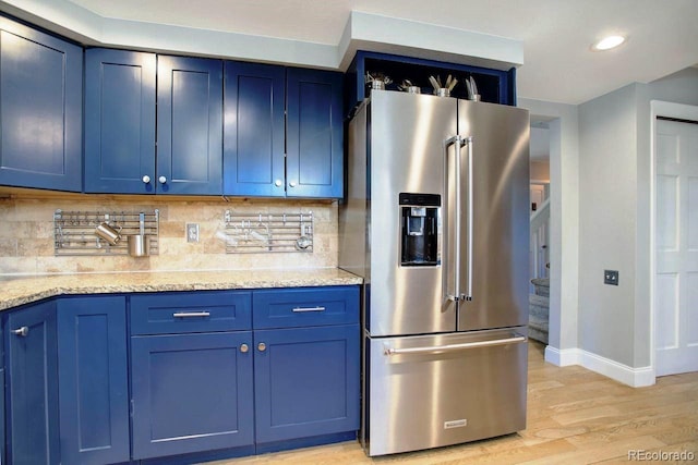 kitchen with tasteful backsplash, blue cabinets, and high quality fridge