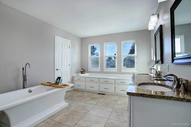 bathroom with a bath, tile patterned flooring, and vanity