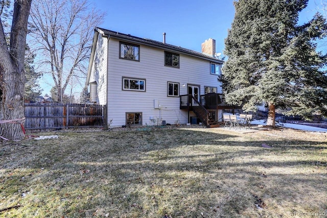 rear view of house with a deck and a lawn