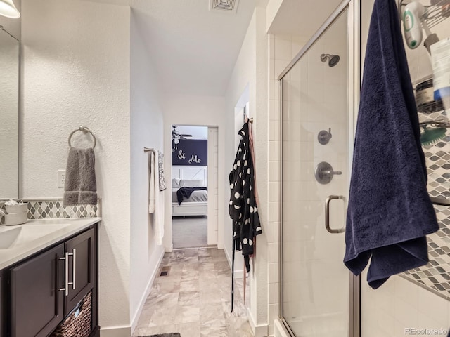 bathroom featuring ceiling fan, vanity, and a shower with shower door