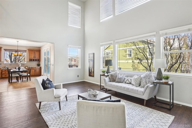 living room with dark hardwood / wood-style flooring and a towering ceiling