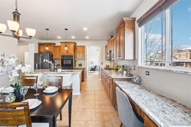 kitchen featuring tasteful backsplash, appliances with stainless steel finishes, and hanging light fixtures