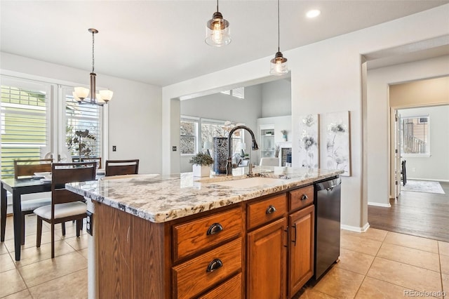 kitchen featuring dishwasher, pendant lighting, sink, and a center island with sink