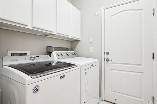 clothes washing area with independent washer and dryer and cabinets