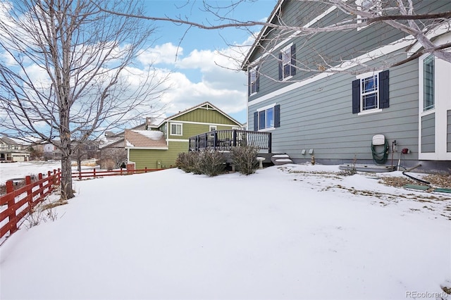 yard covered in snow featuring a deck